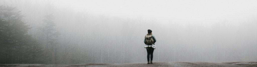 Person standing on a foggy slope, looking to overcome their worries and fears through anxiety therapy in Castle Rock, CO.