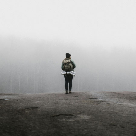 Person standing on a foggy slope, representing the therapy services for anxiety treatment in Castle Rock, CO.