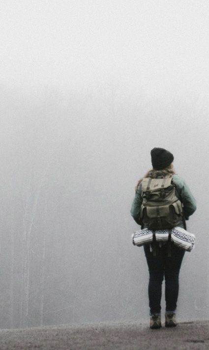 Person standing on a foggy slope, looking to overcome their worries and fears through anxiety therapy in Castle Rock, CO.