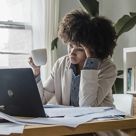 Stressed-out woman at her work desk, in need of help with burnout therapy at Authentic Connections in Castle Rock, Colorado.
