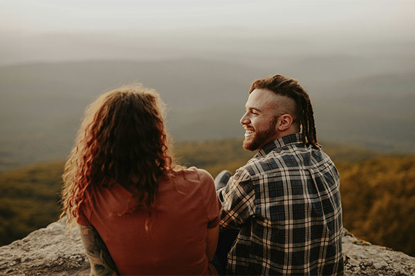 Couple sitting on a mountain looking happy and calm, illustrating the benefits of seeking an anxiety therapist in Castle Rock.