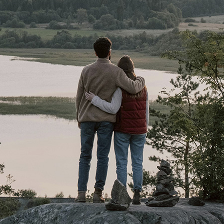 Couple hugging on a cliff, looking to reconnect and improve their relationship through marriage counseling in Castle Rock.