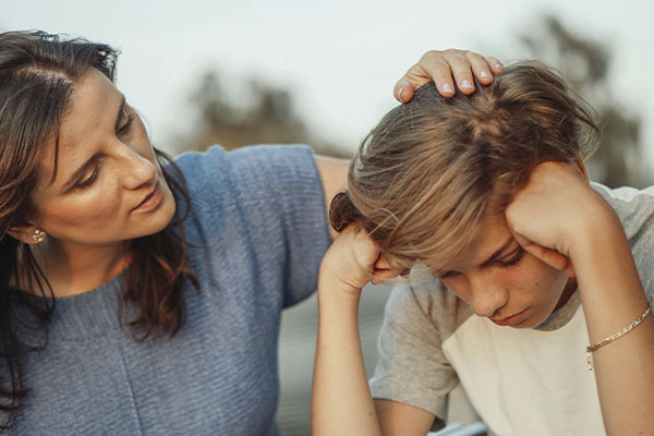 Mother comforting her depressed teenage son, looking to get him help with a teen therapist at Authentic Connections, Colorado.