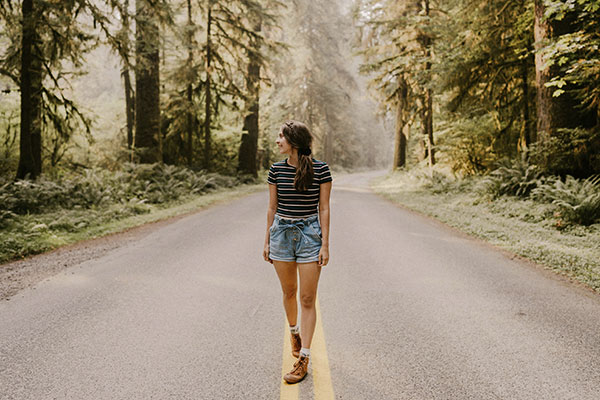 Young woman walking in a forest, feeling happy and free after seeking support from a depression therapist in Castle Rock, CO.