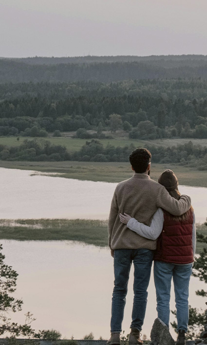 Couple hugging on a cliff, looking to reconnect and improve their relationship through marriage counseling in Castle Rock, CO.