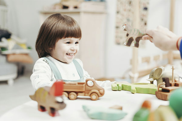 Little kid playing with toys and smiling in child therapy at Authentic Connections in Castle Rock, Colorado.