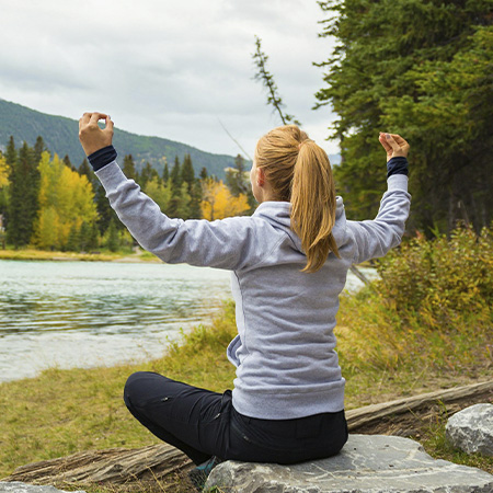 Woman meditating in the mountains, feeling connected with her spirituality after seeking spiritual direction in Castle Rock, CO.
