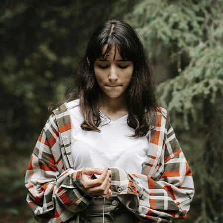 Contemplative teenage girl in forest, looking to start teen counseling with Authentic Connections in Castle Rock, Colorado.