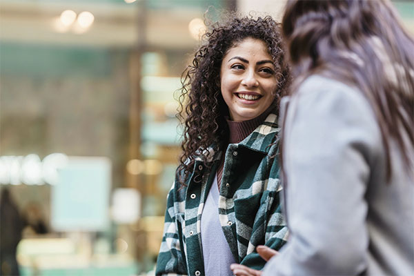 Woman smiling while talking with someone, feeling her mental health has improved after starting depression treatment in Castle Rock.
