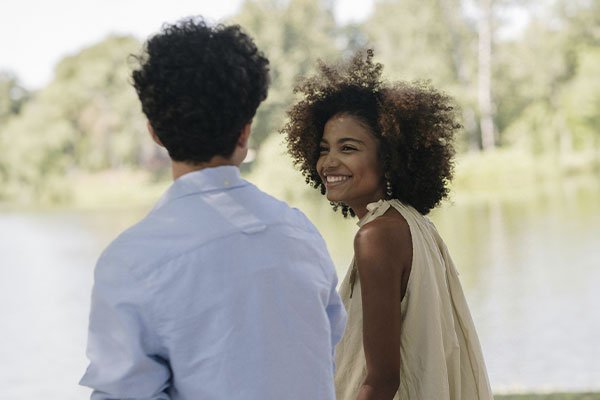 Woman walking together with her partner smiling happily, after getting support from a trauma & PTSD therapist in Castle Rock.