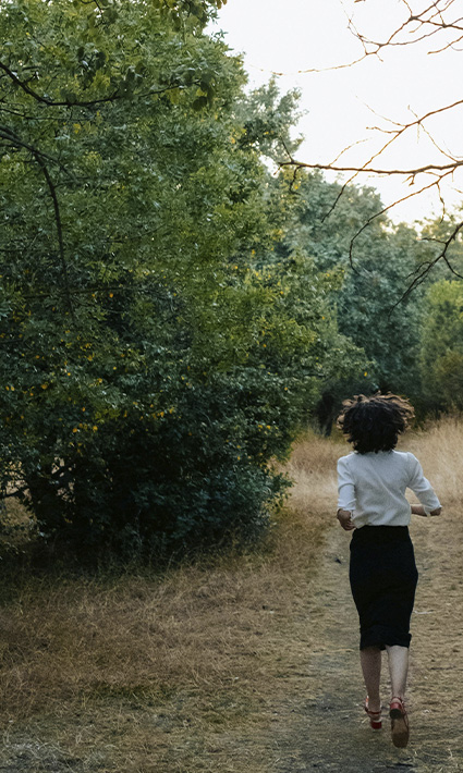 Woman in a forest, running from painful memories before starting trauma therapy & PTSD treatment in Castle Rock.