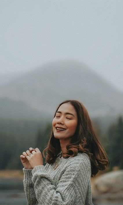 Woman in nature smiling and connected with herself after starting neurodivergence counseling in Castle Rock, Colorado.