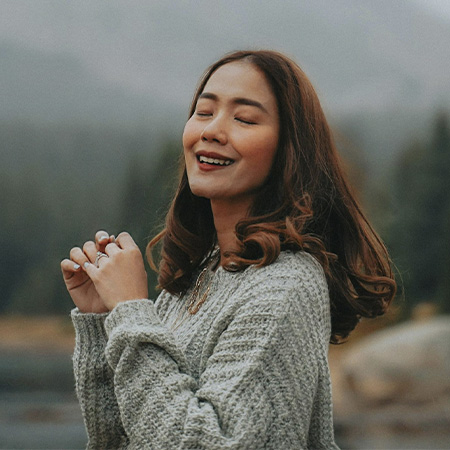 Woman in nature smiling and connected with herself after starting neurodivergence counseling in Castle Rock, Colorado.