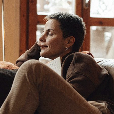 Women sitting in her couch looking peaceful, represents how you can find specialized counseling for women in midlife in Castle Rock, CO.